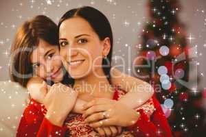 Composite image of festive mother and daughter smiling at camera