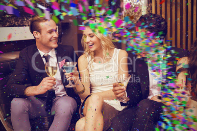 Composite image of happy friends having a drink together