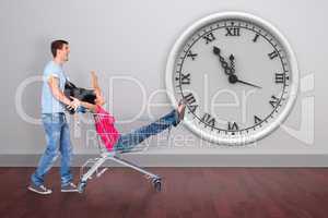 Composite image of young couple having fun with shopping cart