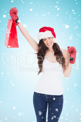 Composite image of festive brunette in boxing gloves with shoppi