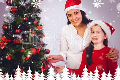 Composite image of mother and daughter hanging christmas decorat