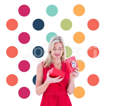 Composite image of stylish blonde in red dress opening gift box