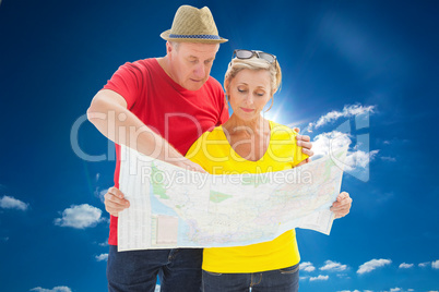 Composite image of lost tourist couple using map