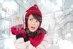 Composite image of young woman shaking her gift in order to gues