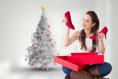 Composite image of content brunette holding red shoes
