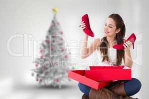 Composite image of content brunette holding red shoes