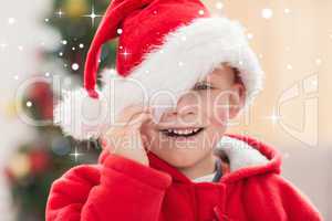 Composite image of festive little boy smiling at camera