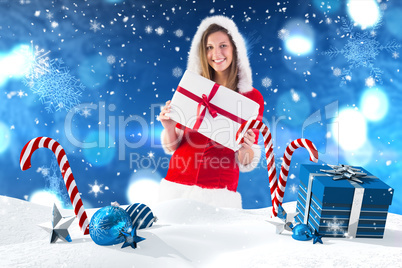 Composite image of pretty santa girl standing with gift