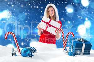Composite image of pretty santa girl standing with gift