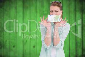 Composite image of pretty woman showing an one hundred euro note