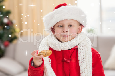 Composite image of festive little boy eating a cookie