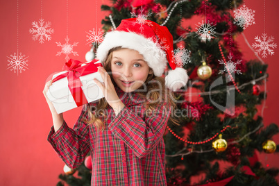 Composite image of festive little girl holding gift