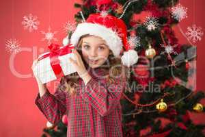 Composite image of festive little girl holding gift