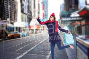Composite image of festive brunette holding shopping bags