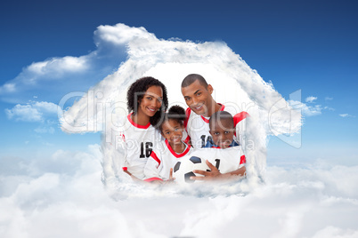 Composite image of smiling family holding a soccer ball