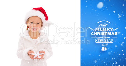 Composite image of festive little girl holding snowflake