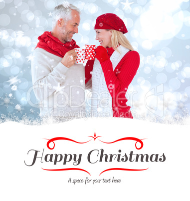 Composite image of happy winter couple with mugs