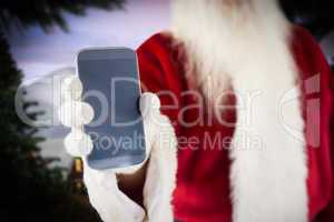 Composite image of santa claus showing smartphone