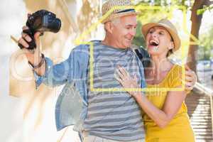 Composite image of happy tourist couple taking a selfie in the c