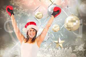 Composite image of festive brunette in boxing gloves cheering