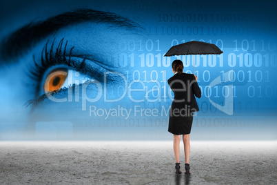 Composite image of young businesswoman holding umbrella