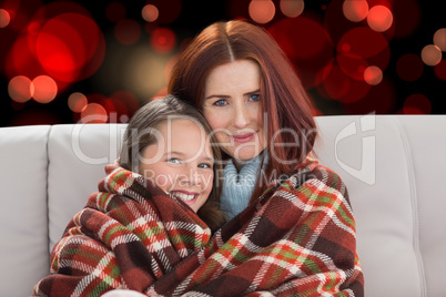 Composite image of mother and daughter under blanket