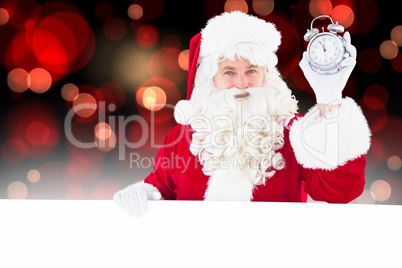 Composite image of santa claus holding alarm clock and sign