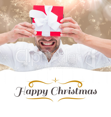 Composite image of festive man holding christmas gift