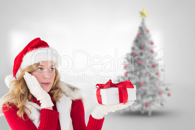 Composite image of pretty woman holding gift in a hand