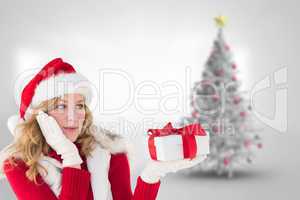 Composite image of pretty woman holding gift in a hand