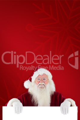 Composite image of santa looks over a sign