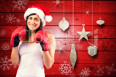 Composite image of festive brunette in boxing gloves
