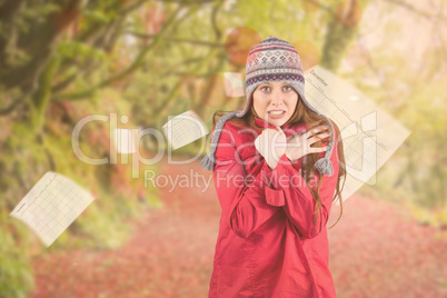 Composite image of cold redhead wearing coat and hat