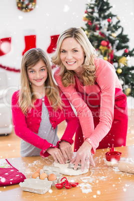 Composite image of festive mother and daughter making christmas cookies