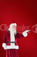 Composite image of santa shows something to camera