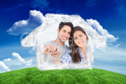 Composite image of man and wife holding a key with a house keych