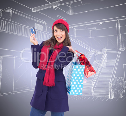 Composite image of brunette holding shopping bags and credit car