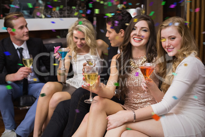 Composite image of happy friends having a drink together