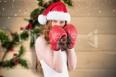 Composite image of festive redhead with boxing gloves