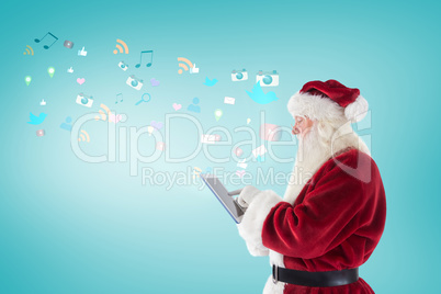 Composite image of santa uses a tablet pc