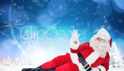 Composite image of relaxed santa lying and waving