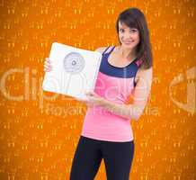Composite image of smiling woman holding weighing scales