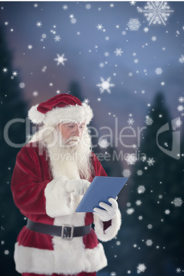 Composite image of santa uses a tablet pc