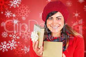 Composite image of smiling brunette opening christmas gift