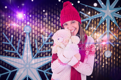 Composite image of cute brunette in warm clothing hugging teddy