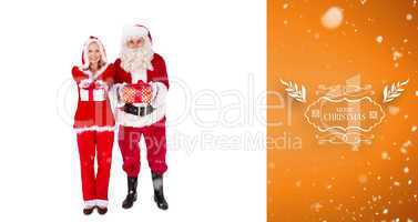 Composite image of santa and mrs claus smiling at camera offerin