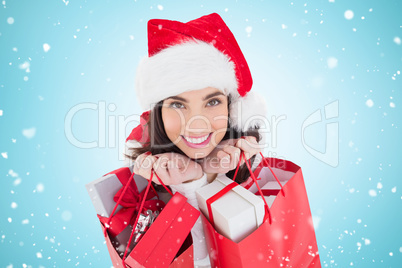 Composite image of smiling brunette holding shopping bags full o