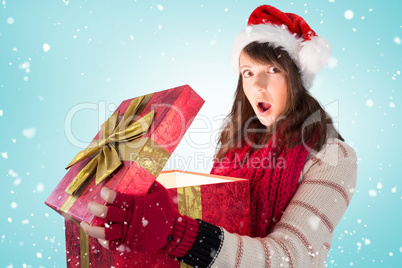 Composite image of young woman opening a glowing christmas gift