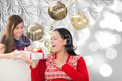 Composite image of mother and daughter with gift