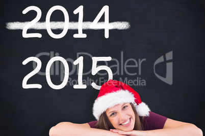 Composite image of festive brunette leaning on large poster